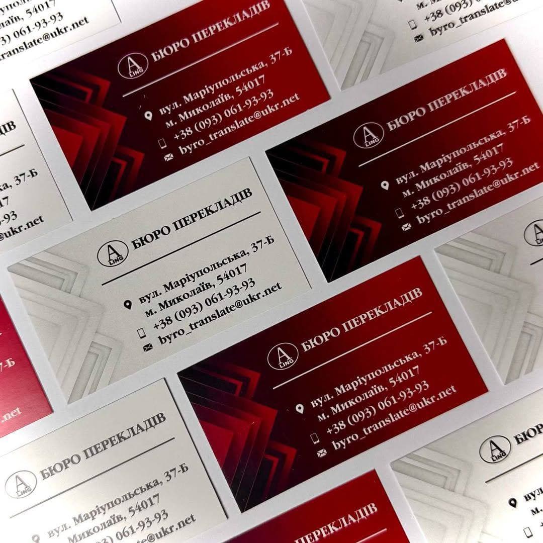 Scattered red and white business cards for a translation bureau with contact information.
