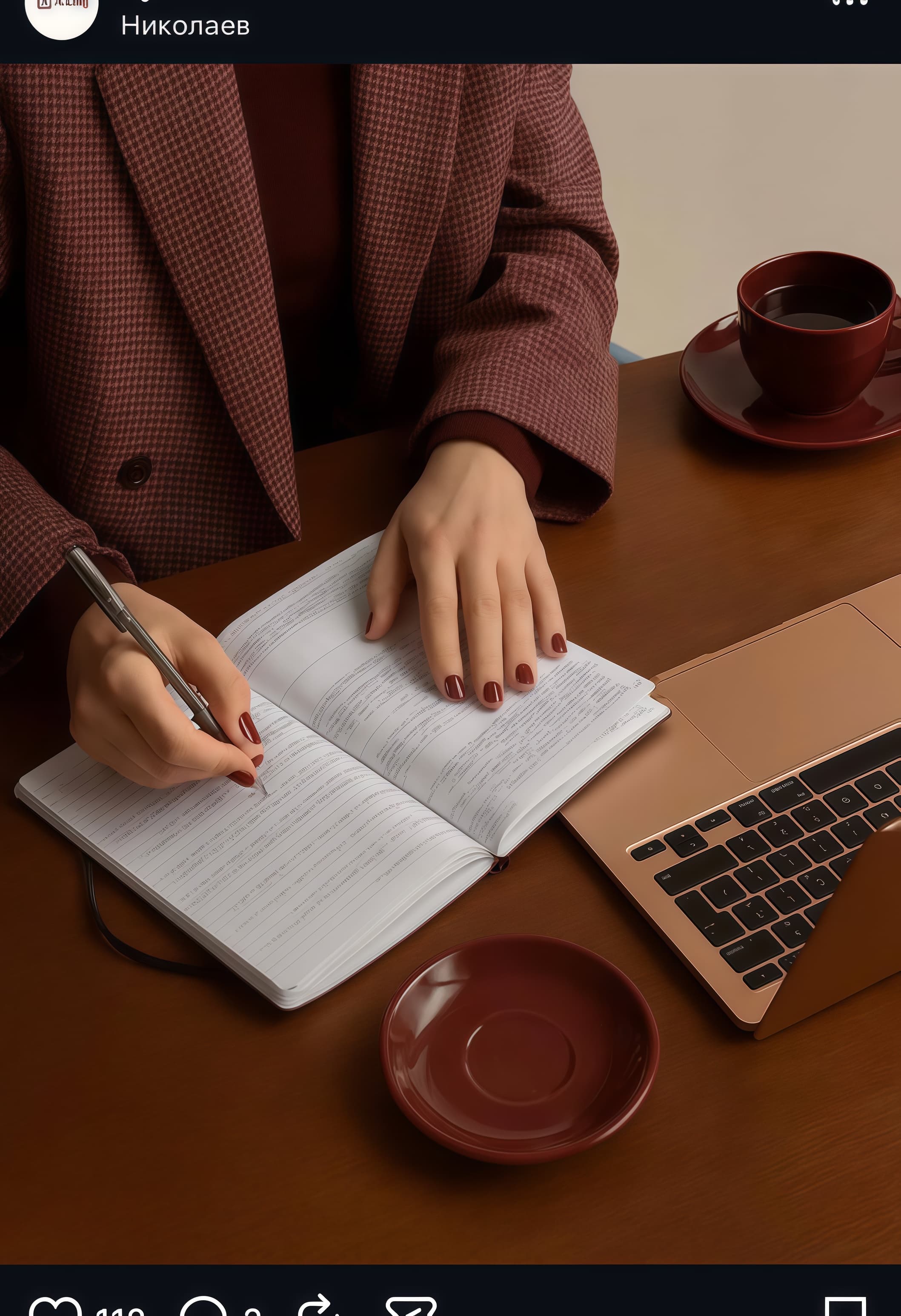 Person in a brown checkered blazer writing in a notebook beside a laptop and coffee.